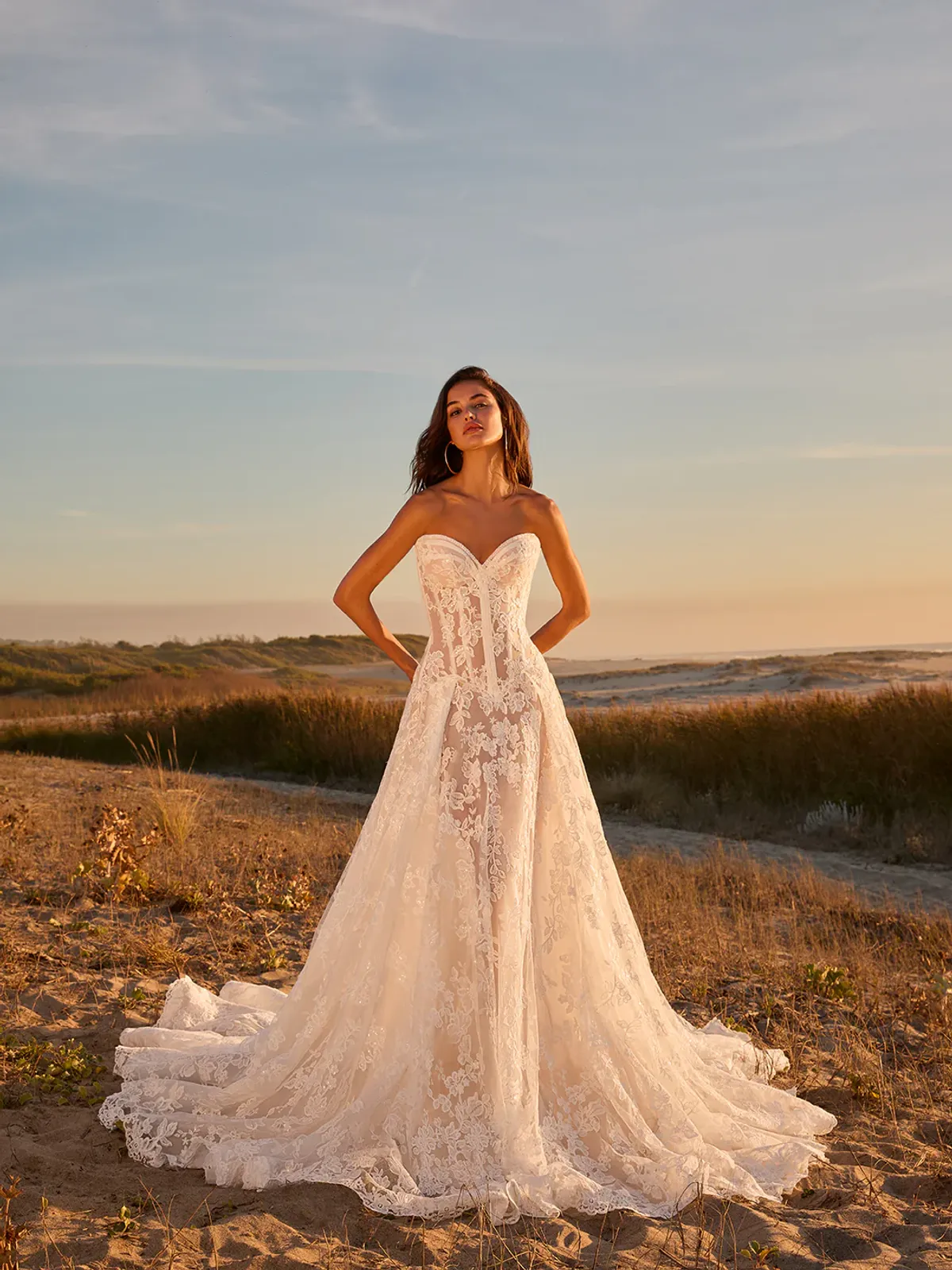 A model showcases the Galia Lahav Aspire dress on a beach