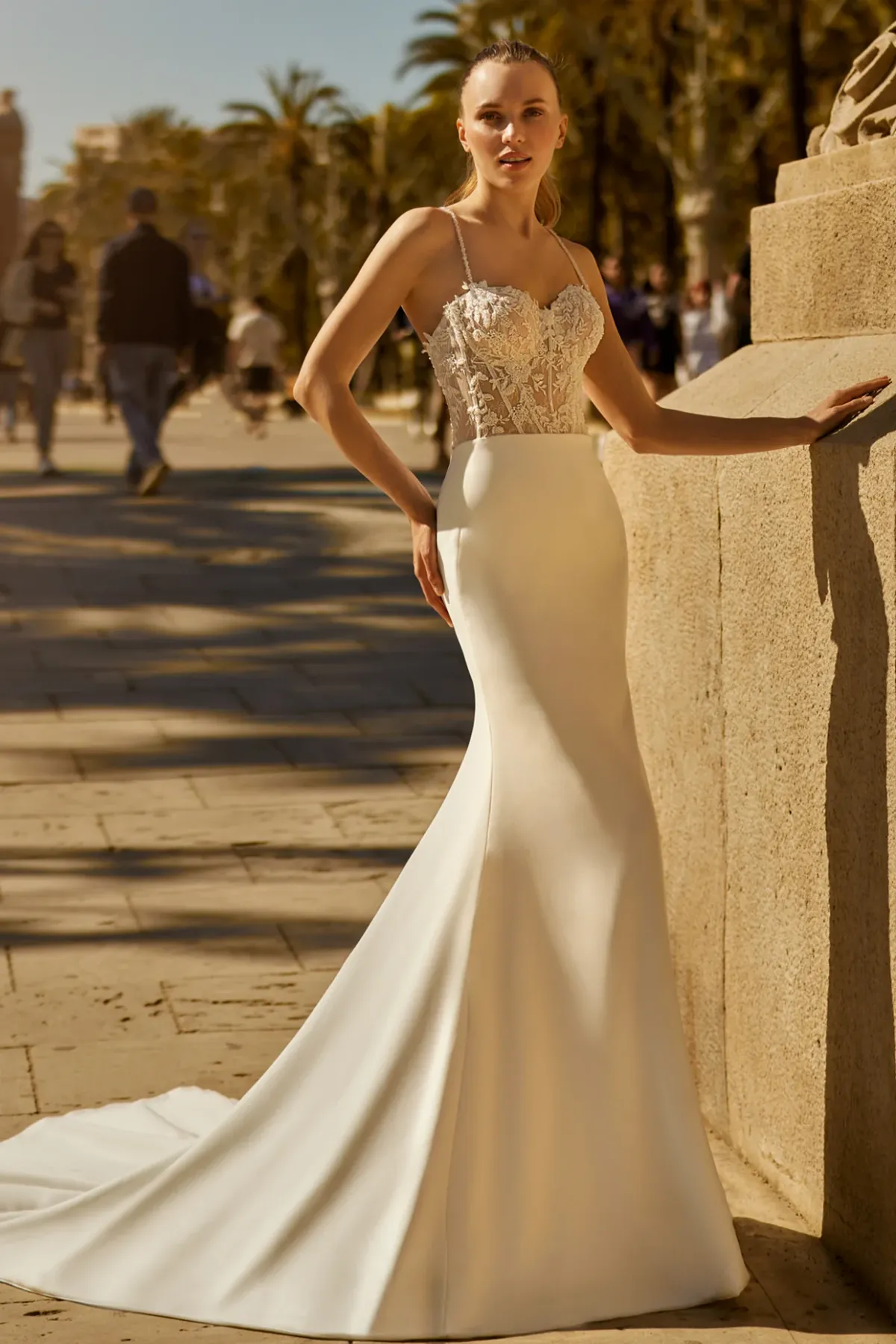 A model showcases the Ines Di Santo Canon dress from the Ines by Ines Di Santo collection outside near a concrete wall
