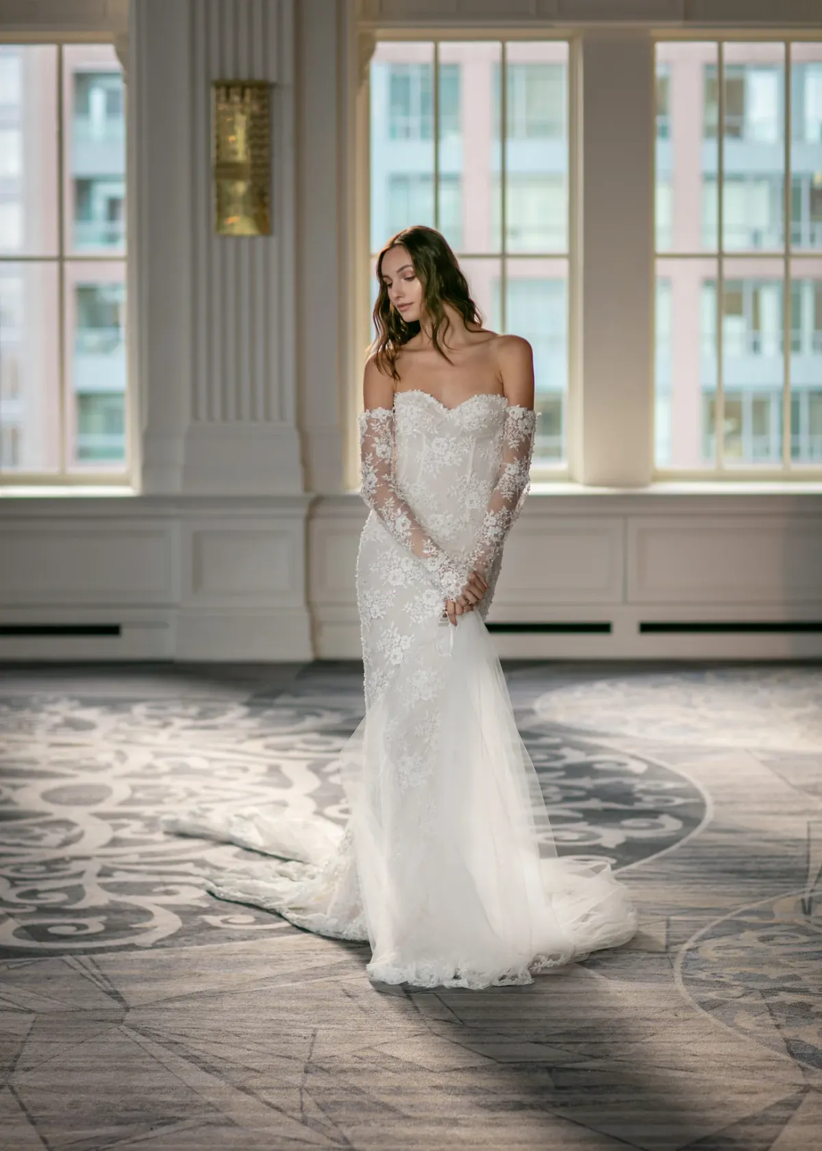 A model showcases the Ines Di Santo chiara dress while standing in a ballroom