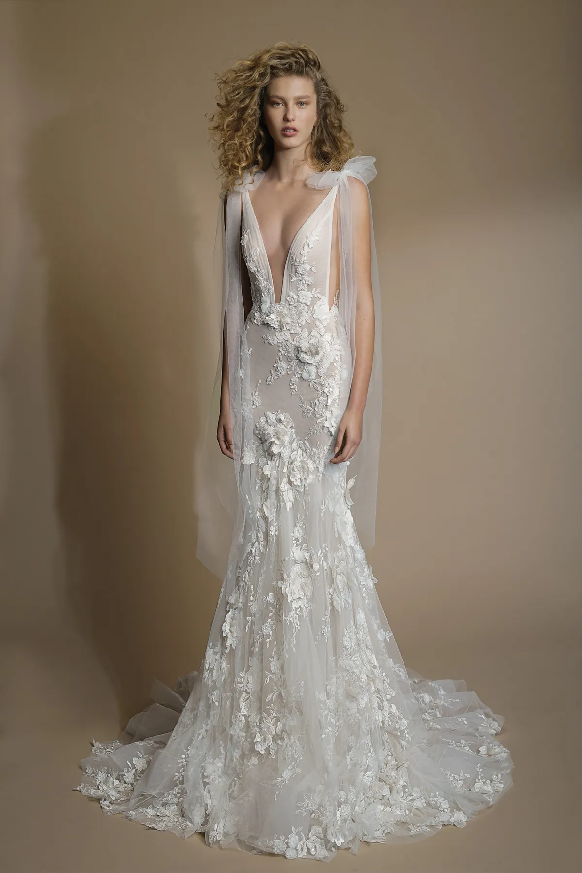 A model showcases the Galia Lahav G-104 dress in a photography studio with a beige backdrop