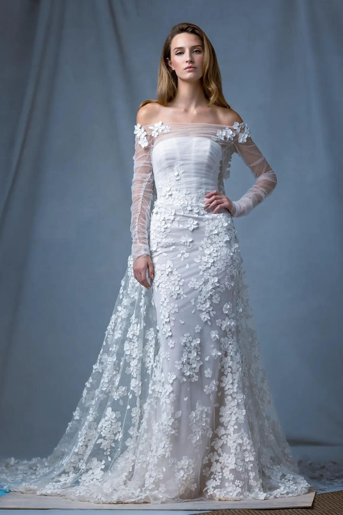 A model showcases the Ines Di Santo Radius dress while standing in a photography studio with gray backdrop