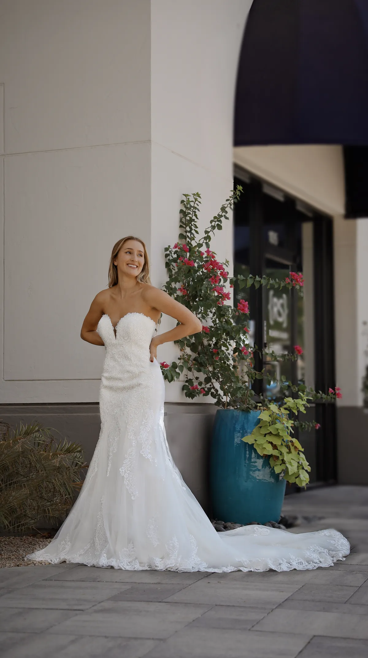 A model showcases the Angel Rivera admire dress while standing outside
