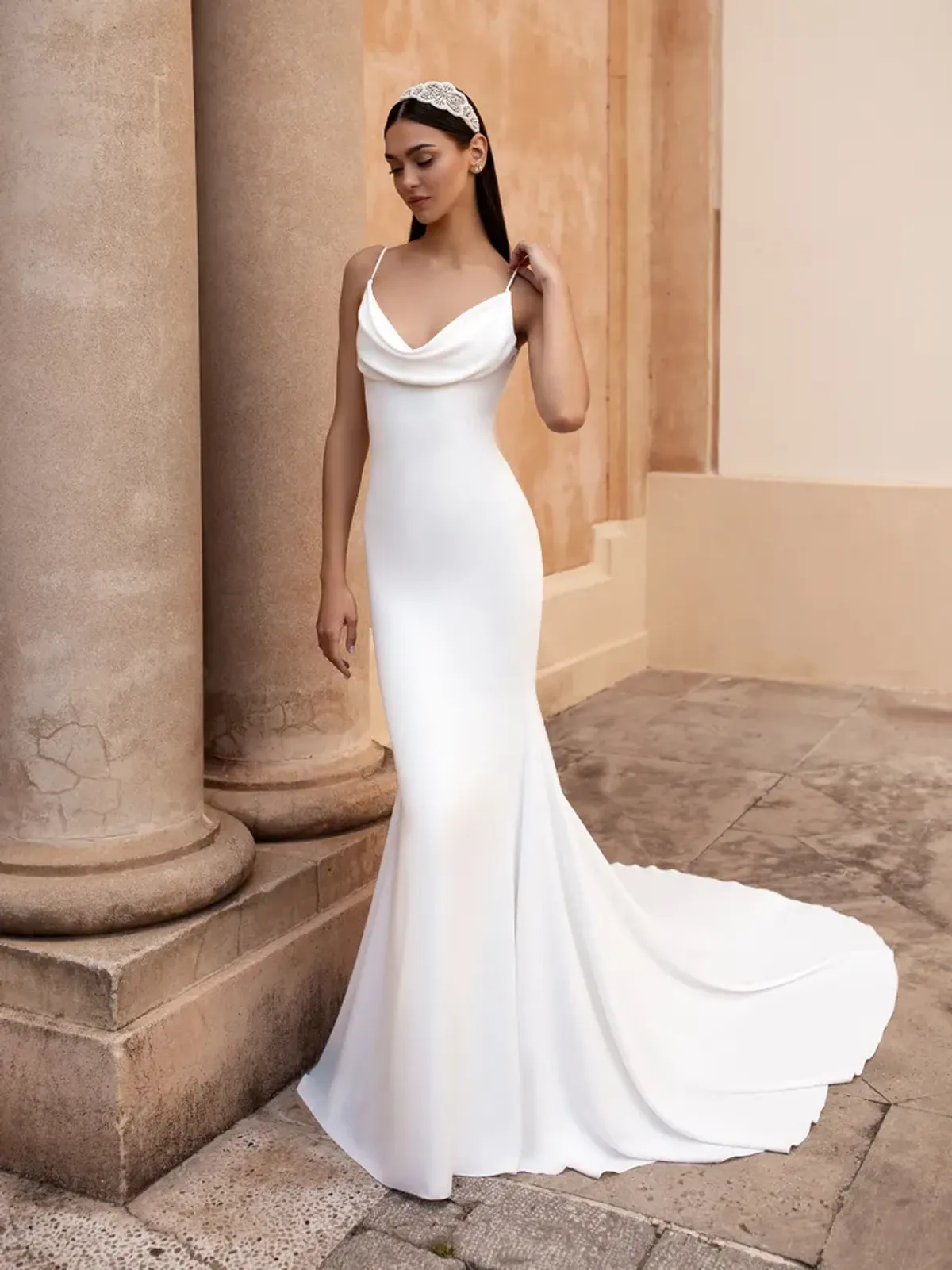 A model showcases the Pronovias Antiope dress near stone columns