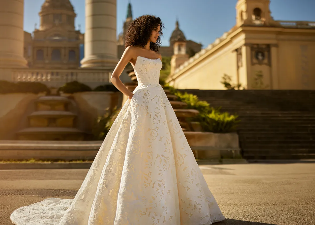 A model showcases the Ines Di Santo Aria dress from the Ines by Ines Di Santo collection in front of a desert palace