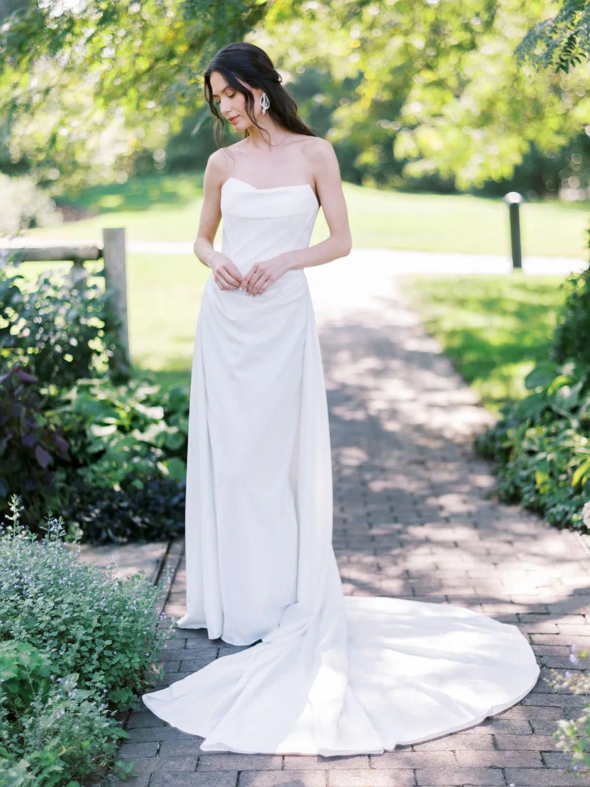 A model showcases the Beccar Cannes dress at a park surrounded by trees