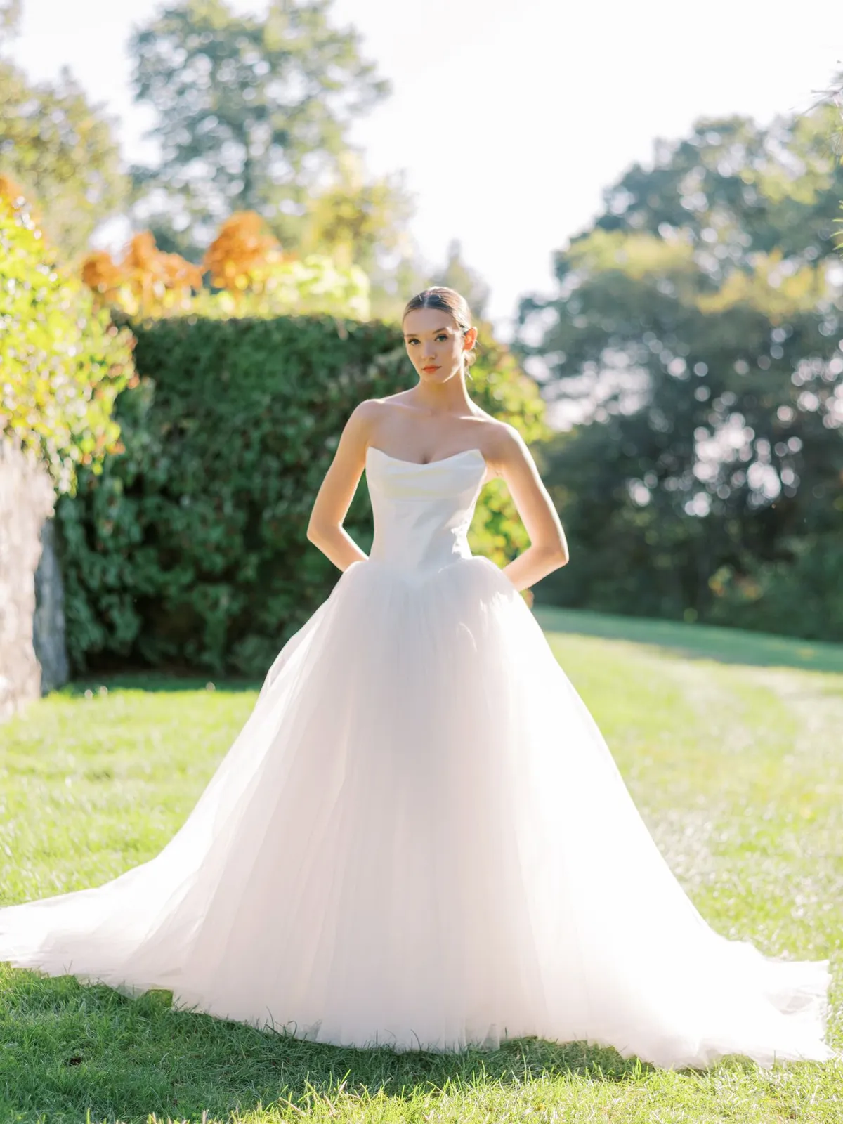 A model showcases the Beccar Cassel dress at a park surrounded by trees