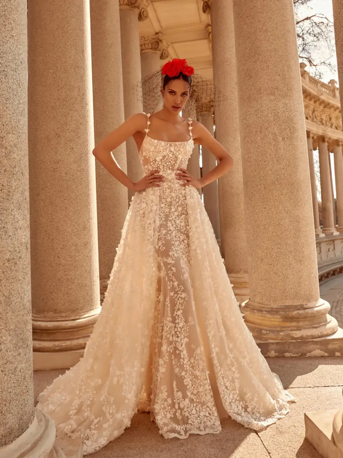 A model showcases the Galia Lahav Catalina dress from the Couture collection near stone pillars outside
