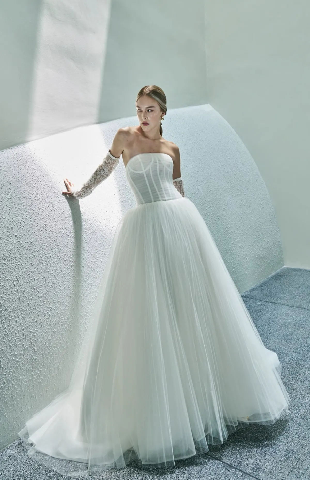A model showcases the Beccar Codi dress in a blue/grey room