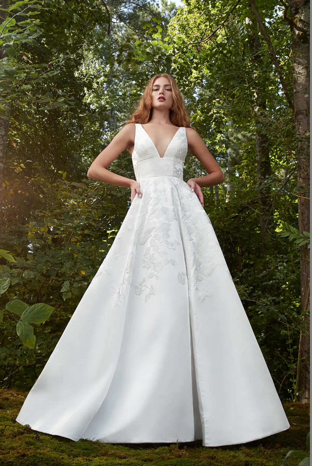 A model showcases the Anne Barge Forever Yours dress in a whimsical forest surrounded by trees