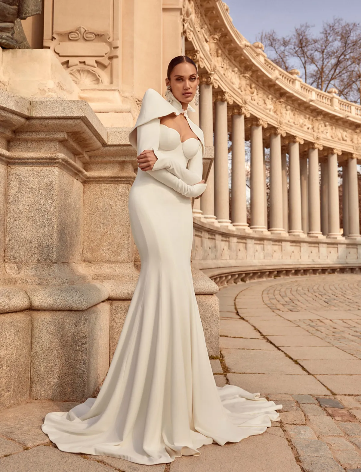 A model showcases the Galia Lahav Nirvana dress from the Couture collection near stone columns