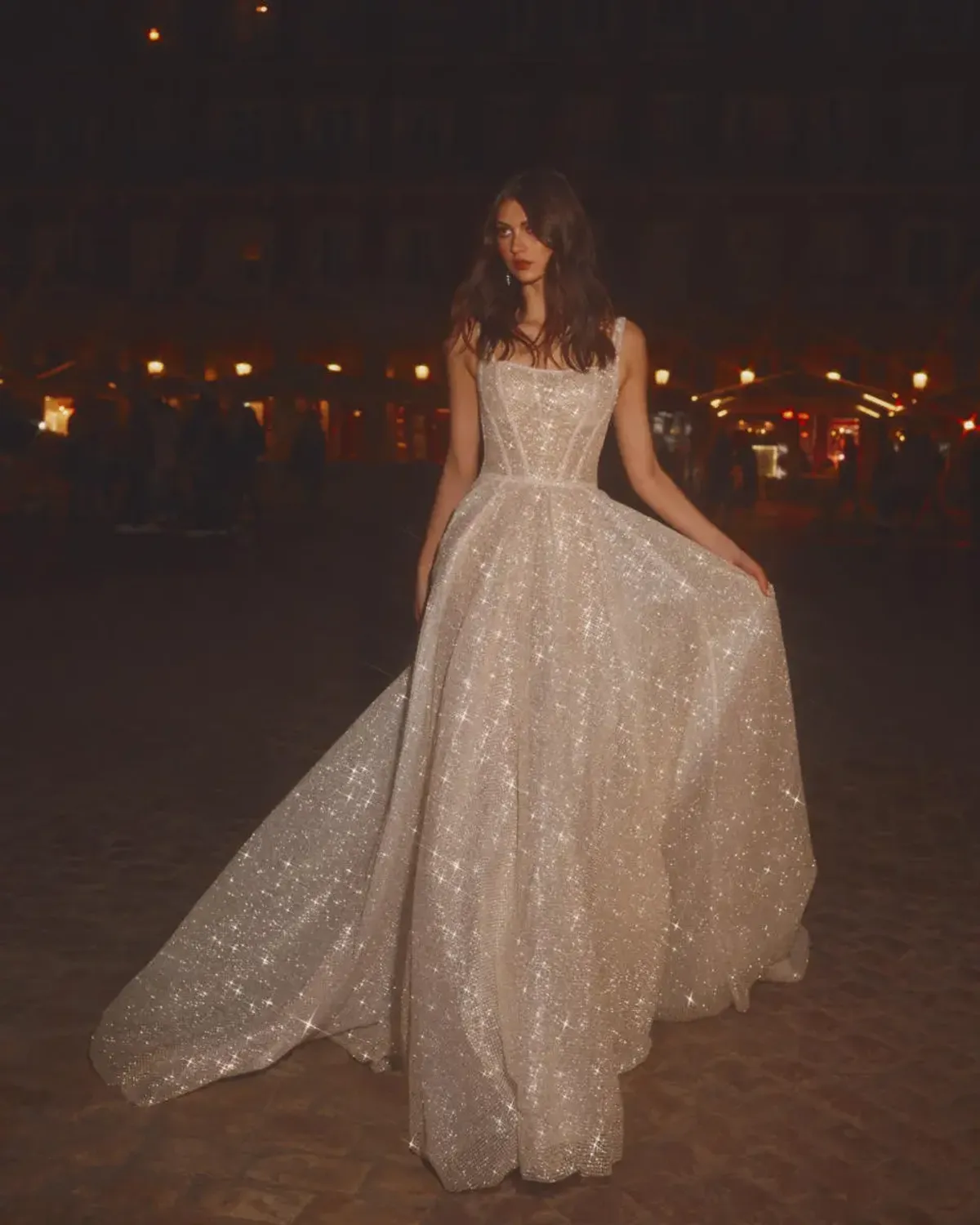 A model showcases the Galia Lahav Gigi dress from the GALA collection outside at night with a hard flash