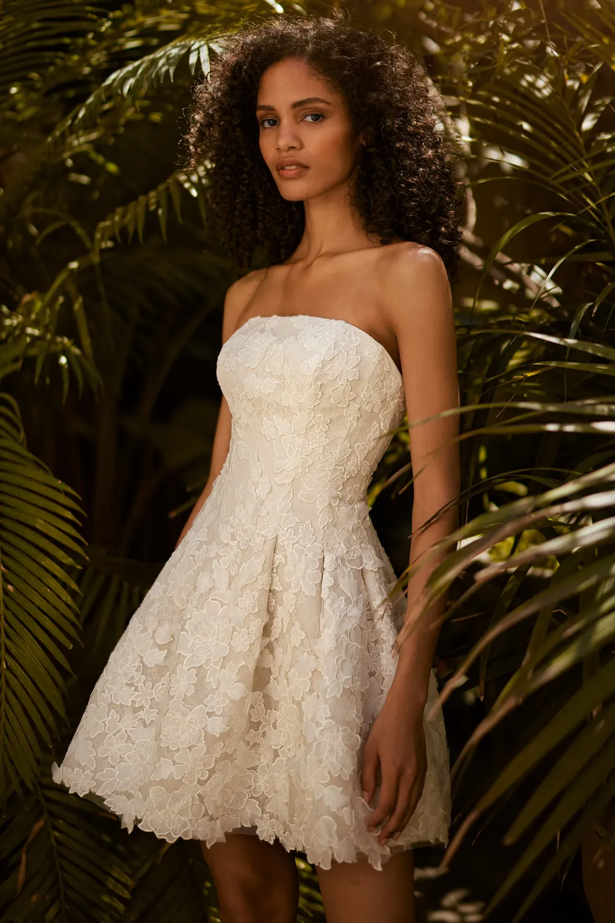 A model showcases the Ines Di Santo Jazz dress from the Ines by Ines Di Santo collection near a garden