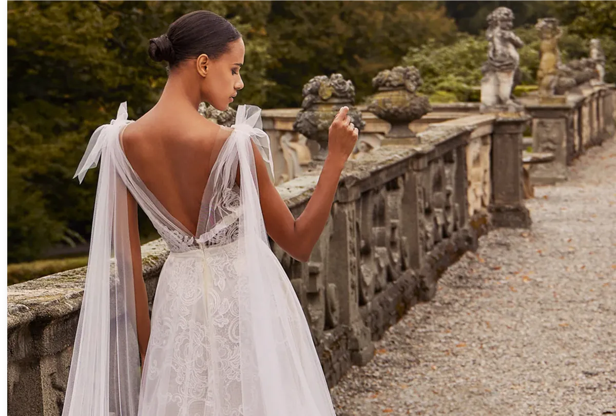 A model showcases an Ines Di Santo a-line dress featuring bows on the shoulder straps