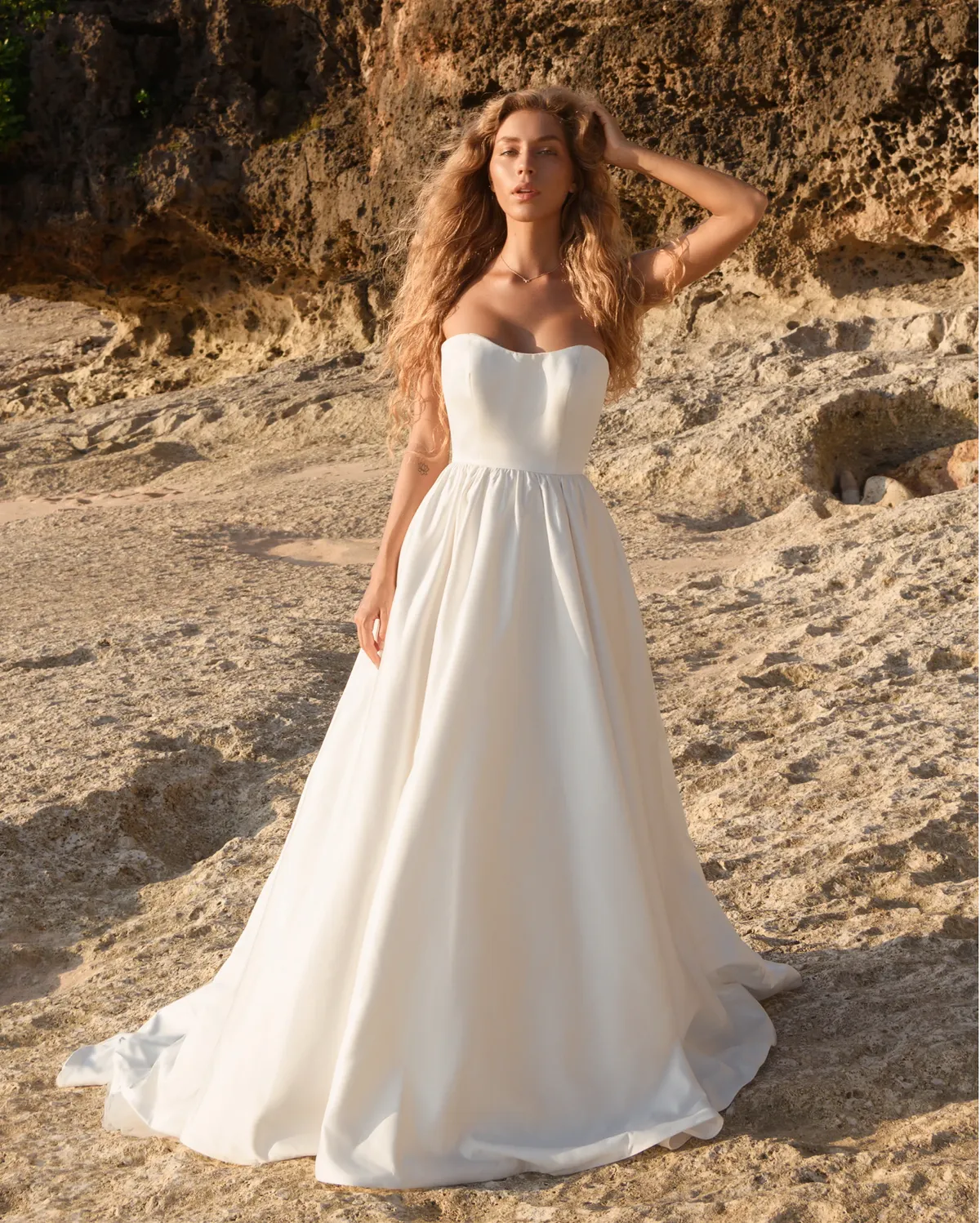 A model showcases the Antonio Gual Ionna dress on a mediterranean beach during summer