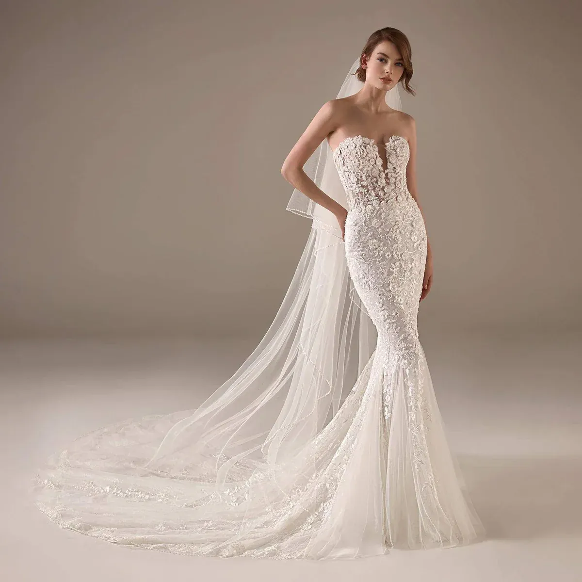 A model wears the Pronovias Jameela dress in a photography studio with white backdrop