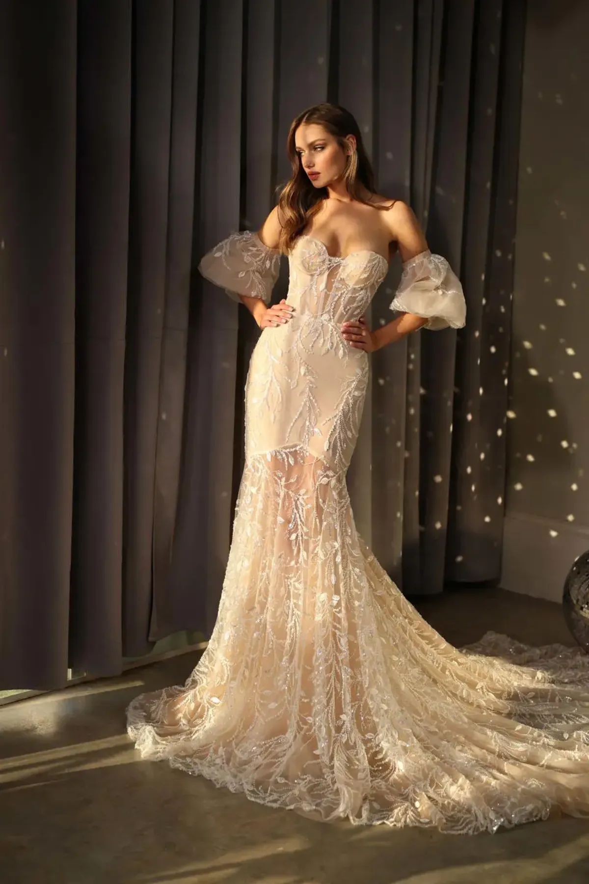 A model showcases the Galia Lahav Jet dress from the GALA collection in a room with accent lighting reflected from disco balls