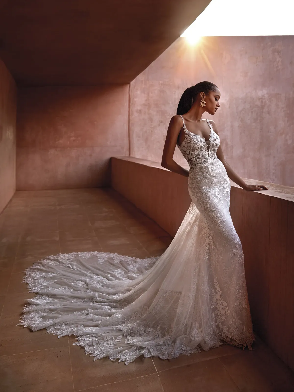 A model wears the Pronovias Seychelles dress on a balcony