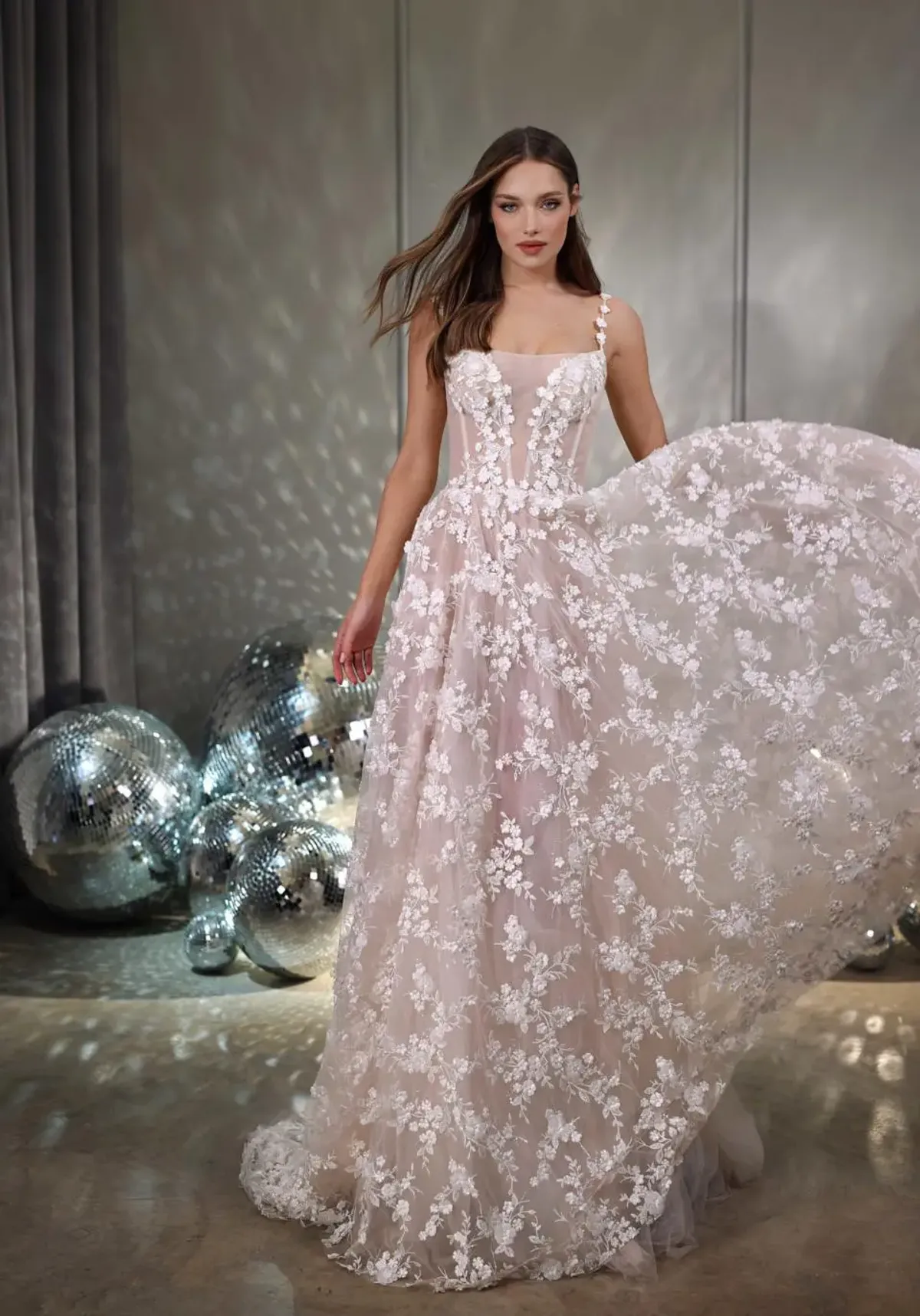 A model showcases the Galia Lahav Twinkle dress from the GALA collection in a room filled with disco balls